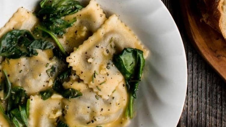 Creamy Garlic and Spinach Ravioli shown made with recipe ingredients and ready to be enjoyed.
