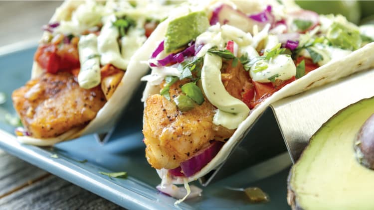 Soft tortillas wrapped around swai and toppings to make fish tacos.